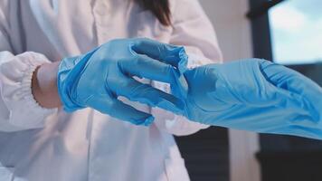 A person in a lab coat is holding a blue glove video