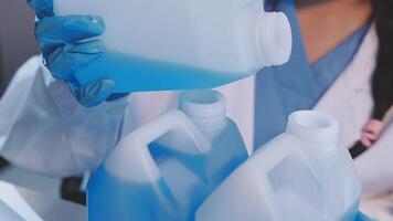 A woman in a lab coat is holding two plastic containers video