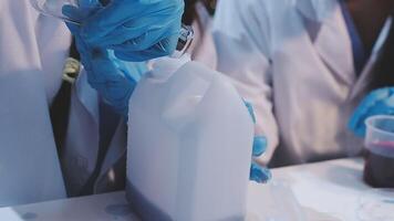 A group of people in lab coats are working on a container video