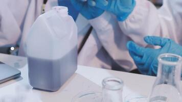 A group of people in lab coats and gloves are working on a project video