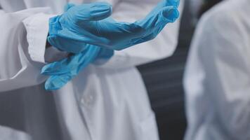 A person in a lab coat and blue gloves video