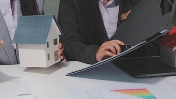 Two business people are looking at a house model video