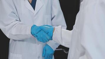 Two doctors shaking hands in a lab video