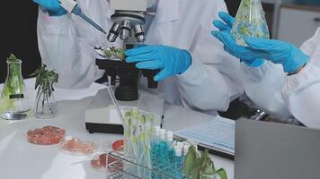 Two people in lab coats and gloves are working on a project video