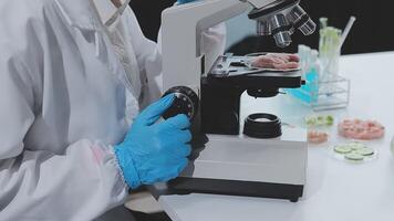 A person in a lab coat is looking at a microscope video