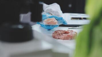 A person in a lab coat is holding a piece of meat video
