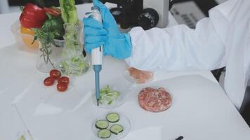 A person in a lab coat is holding a pipette video