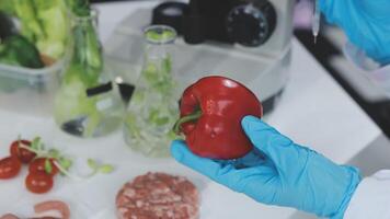 A person in a lab coat holding a red pepper video
