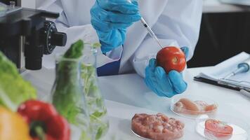 A person in a lab coat is holding a tomato video