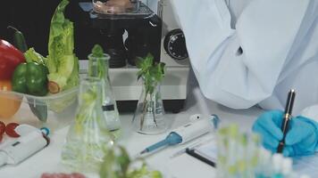A person in a lab coat is working on a microscope video