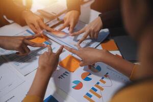 Business people working together on a table with graphs and papers photo