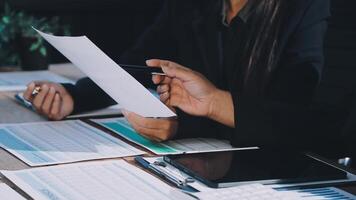 Business people sitting at a table with papers and a pen video