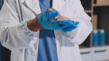 A person in a lab coat is holding a blue glove video