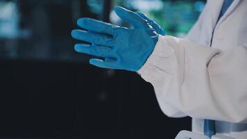A person wearing blue gloves and a white lab coat video