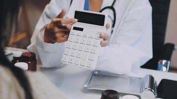 A doctor is holding a calculator while sitting at a desk video