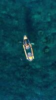 Woman travelling on transparent kayak in ocean. Above drone view video