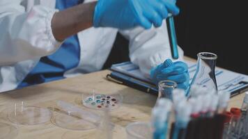 A person in a lab coat is working on a test tube video