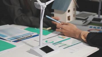 Business people working on a project with a wind turbine video