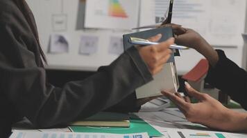 Two people sitting at a table with papers and pens video