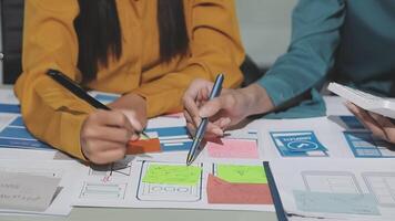 Two people working on a project with paper and pens video
