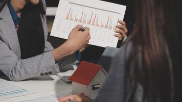 Two business people are looking at a chart on a table video