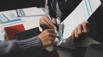 A person is holding a pen and paper while another person is writing on a piece of paper video
