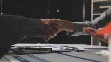 Two people shaking hands over a desk with papers video