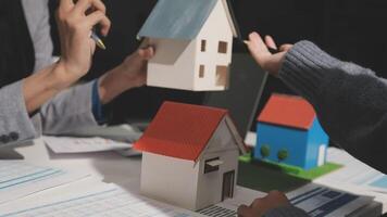 A group of people are holding a house model video