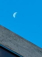 A large moon is in the sky above a building photo