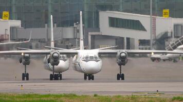 Turboprop aircraft with unrecognizable livery one after another on the airfield, front view video