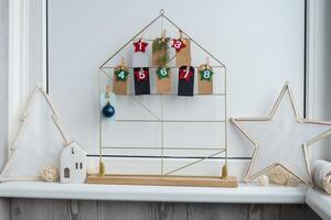 Number on craft paper notes with tasks before Christmas holidays. Female making kraft paper for handmade advent calendar Made with your own hands step by step DIY crafts do it yourself photo