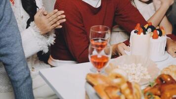 A group of people sitting at a table with food and drinks video