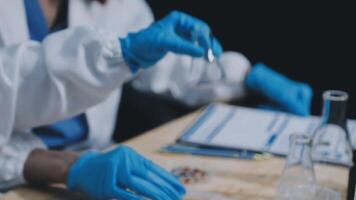 A person in lab coat and gloves is working on a project video