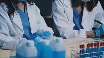 Two women in lab coats and masks working on something video
