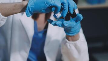 A person in a lab coat and blue gloves is holding a small object video