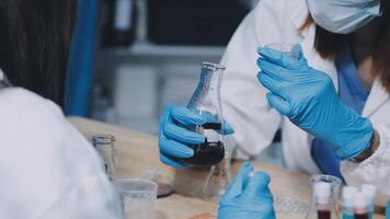 Two people in lab coats and gloves are working on a project video