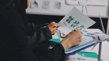 A person is working on a paper with a green leaf on it video