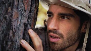 Scared Soldier Hides Behind The Trunk Of A Tree In The Mountains From The Enemy video