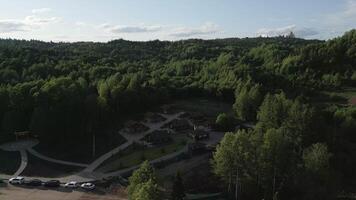 Aerial View of a Lush Green Forest Featuring Charming Rustic Cabins Nestled Amongst Trees. Clip video