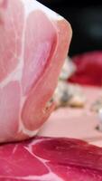 Jamon or dry-cured ham produced in Spain texture close up. 4K resolution Food background. Hand in glove take thin slice of jamon video