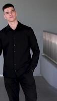 Man in business suit stands leaning on railing of bridge in city center. Manager is in midst of noisy metropolis but headphones allow to concentrate. Man in harmony with pulsating life of modern city. video