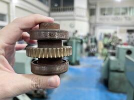 Closeup hand of industrial engineer holding example small gear photo