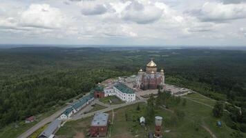 An aerial view highlights an imposing monastery surrounded by lush greenery, depicting beauty. Clip video