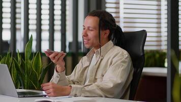 American business man male businessman guy at desk talking mobile phone microphone in office saying smartphone using smart technology dictate commands loudspeaker recording voice mail audio message video