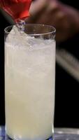 pour soda into a glass Bartender ice cubes making cocktail at bar. Various glasses for alcoholic drinks full of ice in front of bartender at bar counter video