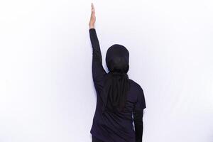 a woman in a black outfit is reaching up photo