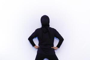 a person in a black hoodie standing on a white wall photo
