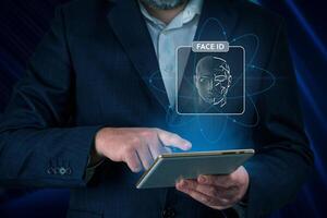 Man using tablet with face id scan and modern technology. Login using Face id and AI. Network security, digital banking, financial technology, online payment. Smart devices security photo