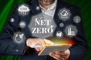 Businessman using digital device to get information about Net zero. Net zero emission, Clean technology, Renewable energy concept. photo