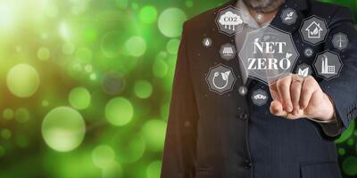 Businessman using digital device to get information about Net zero. Net zero emission, Clean technology, Renewable energy concept. photo